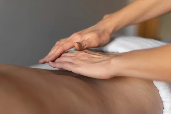 Client booking a professional home massage service in Mayur Vihar, Delhi using a smartphone with an experienced male therapist.