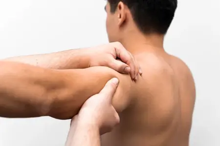 Trained therapist giving deep tissue massage therapy for lower back muscle stiffness