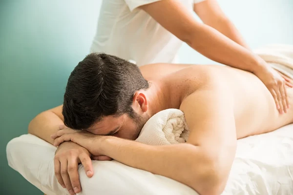 Male therapist performing post travel recovery and weekend stress relief body massage in Tagore Garden