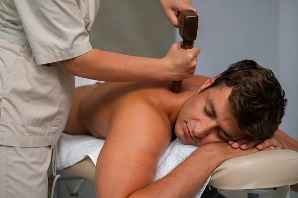 Male client enjoying a relaxing male to male body massage session in a hotel room in Shimla.