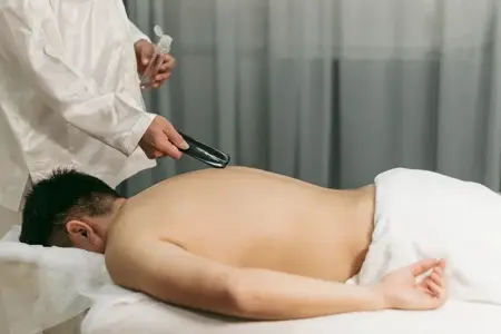 Certified male therapist assisting a client with traditional Thai massage stretches in Delhi.