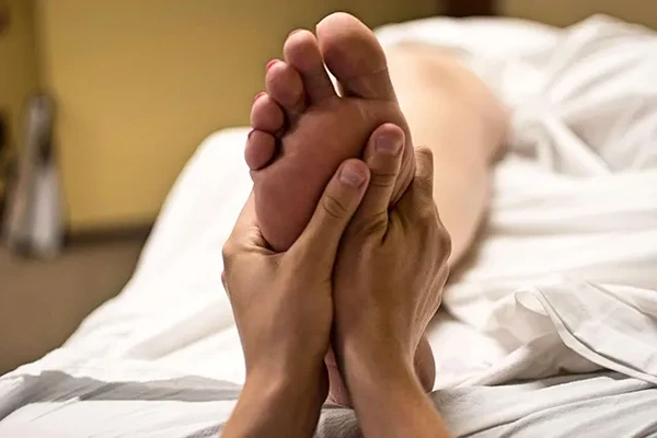 Male therapist providing a sports massage to an active client in a comfortable and private indoor setting in Delhi NCR.